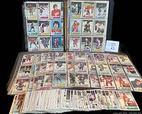 Overview of hockey cards in binder and stacks, showing quantity and storage format
