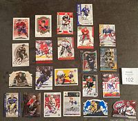 Photo showing all 22 signed NHL cards laid out on a flat surface, displaying a mix of players and teams with visible signatures.