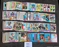 Overview photo showing multiple stacks of football cards laid out to display assortment and quantity in lot, featuring a variety of players and card backs.