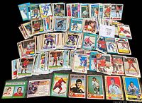 Photo showing a large spread of hockey cards laid out with many characters and teams, cards from the 1970s to 1980s with bright colored borders and player images