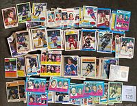 Photo of spread out hockey cards showing front portrait images and team details including Flyers, Canucks, Rangers, and others