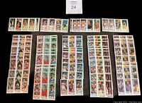 Display of 79 basketball trading cards laid out on black background in multiple rows, showing full collection in lot.