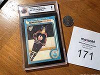 Overall front view of card in protective holder next to coin for scale