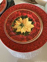 Red and green bordered holiday plates with yellow poinsettia design