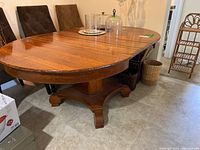 Angle showing the entire rectangular tabletop with rounded corners, and the items on top like glassware which are excluded from sale. Table surface shows light scratches.