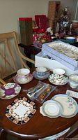 Wide view of assorted tea cups, trays, and packaged spoons on dining table