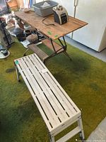 Photo showing Werner aluminum work bench with white slatted platform and various items on top including Oster blender base and miscellaneous pots.