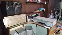 Photo showing Pioneer stereo receiver, Panasonic speakers, JVC VCR, and Concord stereo system on wooden surface.