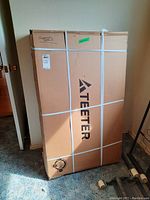 Full front view of sealed Teeter inversion table box against wall.