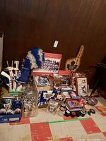 Wide view showing assortment of Toronto Maple Leafs collectibles including hockey flags, magazines, posters, puzzle box, and various memorabilia arranged on floor against wall.