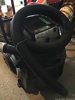 Overall view of Craftsman wet/dry vacuum blower showing main body, attached hose coiled on top.