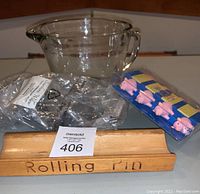 Hocking glass batter bowl behind vintage wooden rolling pin holder with engraving and new sealed pig corn holder sets
