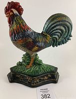 Front angle of the hand painted cast iron rooster door stop showing detailed coloration and base design.