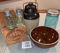 Full view of all items including jars, bowl, shakers, and wooden crate on a wooden surface