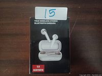 Photo of retail box front showing true wireless stereo earbuds and charging case illustration with Bluetooth 5.0 branding.