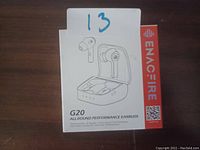 Photo showing the Enacfire G20 All Round Performance Earbuds product box with line drawing of earbuds and charging case, with brand name and product details visible.