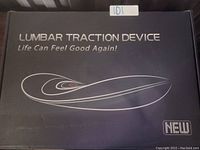 Black box packaging showing 'Lumbar Traction Device Life Can Feel Good Again!' with a sleek, modern design and 'New' label.