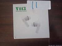 Photo showing the front of the retail box for Y113 True Wireless Headset earbuds, white earbuds pictured on box.