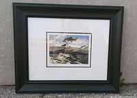 Framed artwork showing the full piece including green frame and matting on a neutral background.