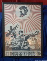 Front view of framed propaganda poster depicting soldiers and citizens with a red sunburst and leader's portrait above. Chinese characters appear at the bottom.