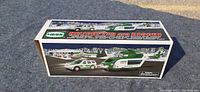 Full view of the box featuring images of the Hess helicopter and rescue vehicle and winter holiday background.