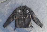Front view of black leather ladies coat with rose cutout design on chest, zip closure, and side lace-up details.