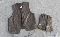Brown leather vest and matching leather gloves laid flat on grey surface, showing front side of vest with pockets and gloves with decorative elements.