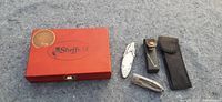 Photo showing the closed Sheffield keepsake box and the three cutting tools including two folding knives and one tool in a black leather sheath.