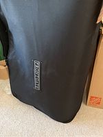Black storage bag with Frontgate logo, containing the Frontgate Easy Bed.