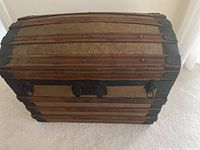 Front view of trunk showing wood slats, embossed metal panels and latch