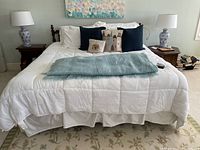 Full front view of king bed with bedding and throw pillows