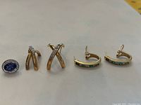 All five earrings arranged in a row on neutral background
