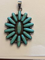 Front view of Native American turquoise pendant showing radial layout of petit point turquoise stones and silver bead accents.