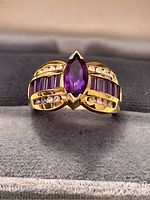 Front view of ring showing marquise-cut amethyst center and surrounding stones