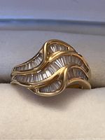 Front view of 14K gold swirl ring with channel-set baguette stones
