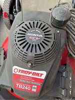 Close-up of Troy-Bilt TB240 lawn mower engine cover showing Honda GCV 160 engine badge and Troy-Bilt branding.
