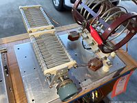 Full view of one ham radio antenna tuner showing multiple aluminum variable capacitor plates with green plastic tuning knob.