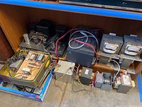 Various vintage power transformers and electrical components arranged on a shelf, with visible wiring and mounting structures.