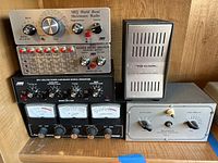 Full view of the radio equipment stacked, showing all items in the lot including MFJ devices, Realistic speaker, and antenna coupler