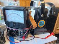 Two Simpson 270 analog multimeters, one with leather strap