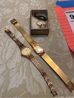 Overall view of the lot showing two watches, a jewelry box with a green pendant and an opal ring.