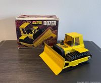 Yellow 1970s Buddy L Big Brute bulldozer steel toy alongside original box on table