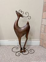 Front view of large metal reindeer ornament showing overall shape, body, and base stand design.