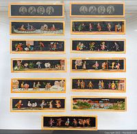 Top-down photo of all 13 rectangular framed magic lantern slides laid out showing both folk tale scenes and portraits of US presidents.