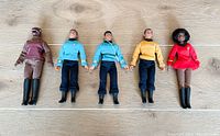 All five Star Trek action figures laid in a row including Gorn, McCoy, Spock, Kirk, and Uhura, showing overall worn condition.