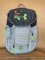 Front view of new Under Armour Undeniable II backpack in gray and black with neon green zippers and logo, tags attached.