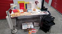 Photo showing entire lot on and under folding table, including pads, art bin with pencils, canvases, and Verilux lamp