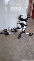 Full view of Vive collapsible rollator walker and parts including wheels, sliders, knee sleeve, and blood pressure monitor