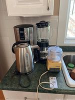 Photo showing Mr. Coffee coffee maker, Cuisinart blender, and Cuisinart Mini-Prep Processor on kitchen counter near sink
