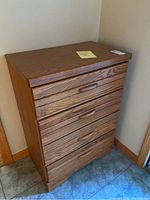 Front view of wooden dresser with four drawers, showing wood grain and drawer handles.